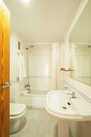 A bathroom with a toilet, sink, and bathtub. - Torre San Diego (Benidorm)