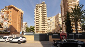 Um edifício alto com várias varandas e um portão fechado.