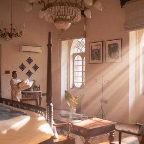 A room with a bed, a chandelier, a window with a view, and wall decorations. - Brij Casa Susegad, Goa (Loutolim)