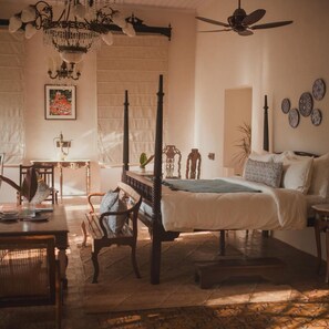 A bedroom with a four-poster bed, a ceiling fan, a chandelier, and a large window. - Brij Casa Susegad, Goa (Loutolim)
