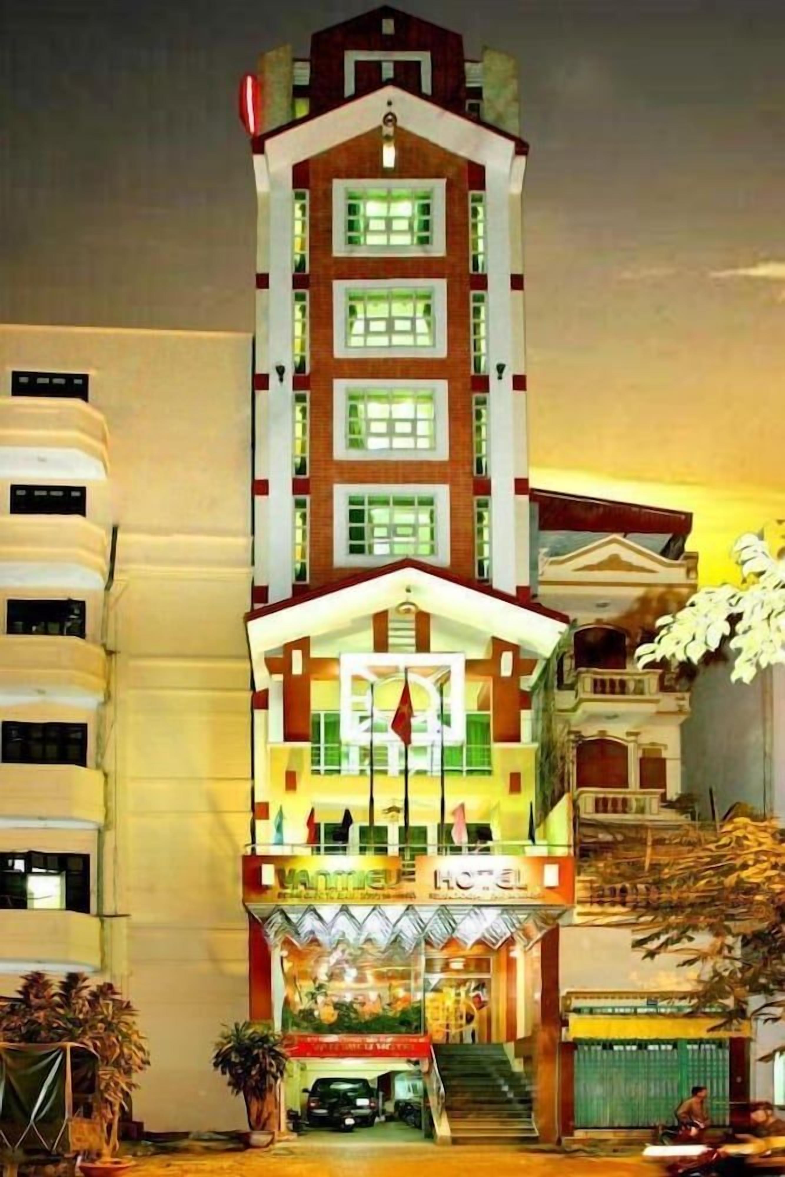 A hotel with a central entrance, multiple floors, and a flag on top.