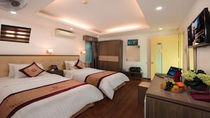A hotel room with two beds, a desk with a fruit bowl, a TV, and a wardrobe. - Hotels Van Mieu (Hanoi)