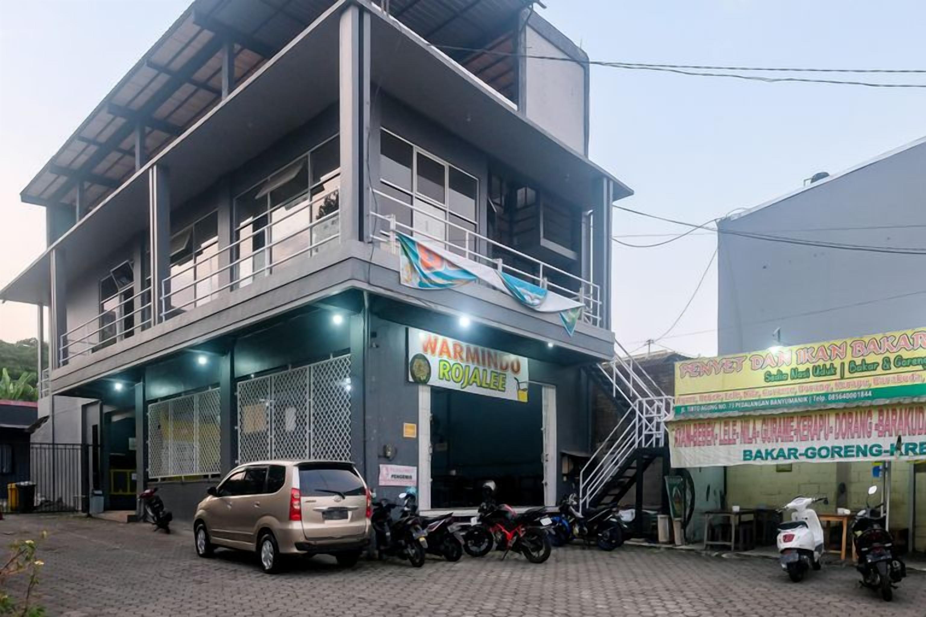 A multi-story building with a ground-level shop and a staircase leading to an upper floor.