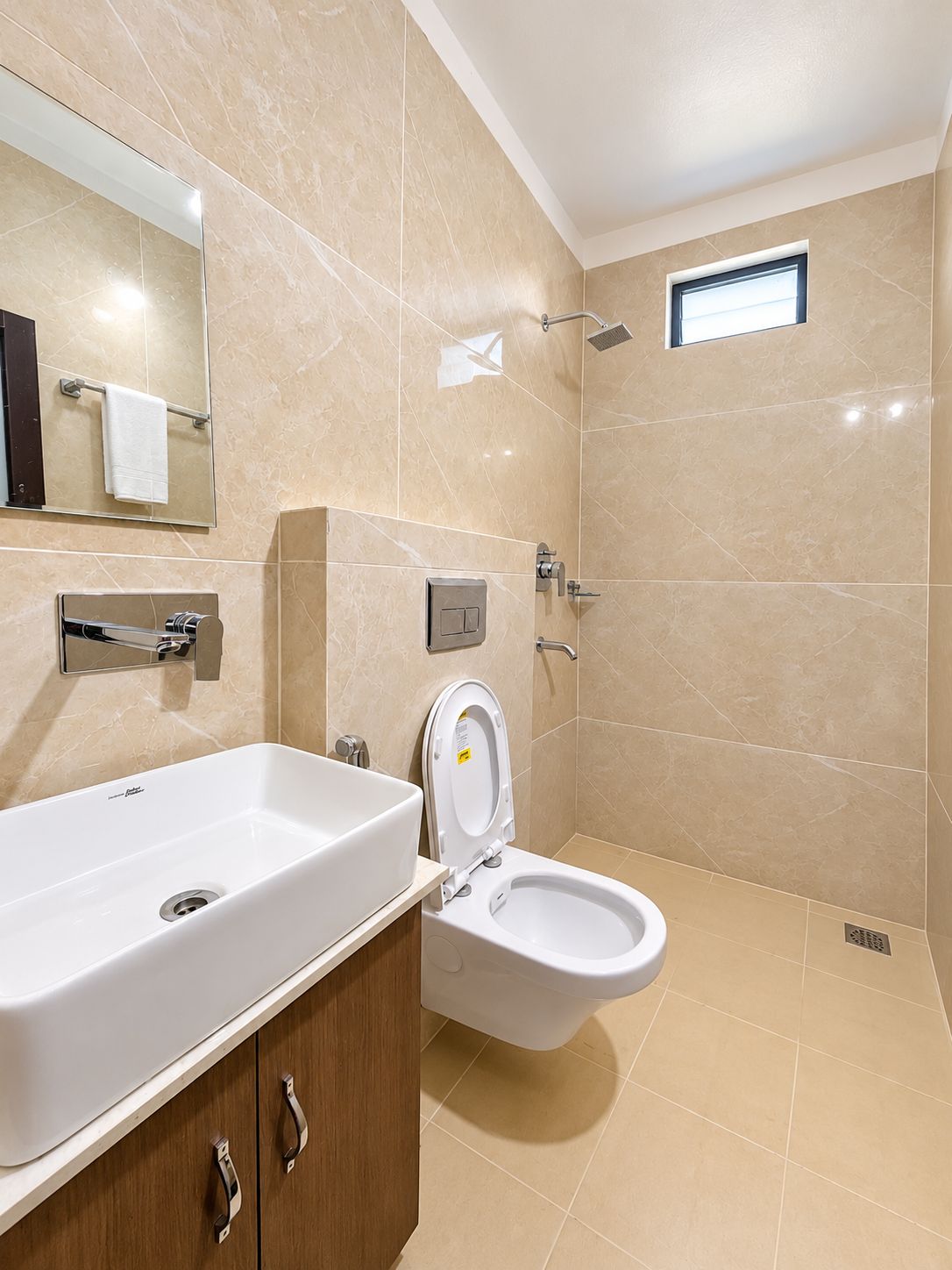 Un baño moderno con un lavamanos grande blanco, un inodoro y una ducha.