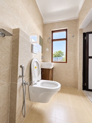 Ein modernes Badezimmer mit Toilette, Bidet und Dusche.