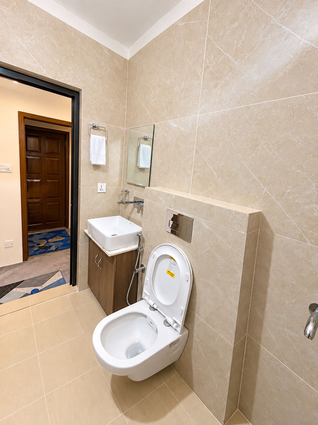 A modern bathroom with a toilet, sink, and mirror.