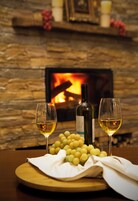 Una mesa con dos copas de vino blanco, una botella de vino y un racimo de uvas.