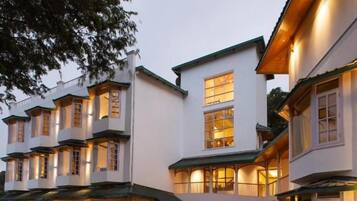 Un edificio de varios pisos con un patio, iluminación exterior y una mesa de picnic.