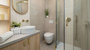 Une salle de bain moderne avec une baignoire sur pieds, des toilettes et un espace douche.