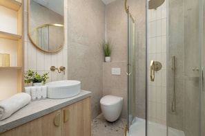 Een moderne badkamer met een vrijstaand bad, een toilet en een douchecabine.