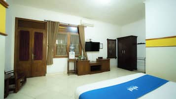 Un dormitorio con cama, escritorio, armario y televisor.