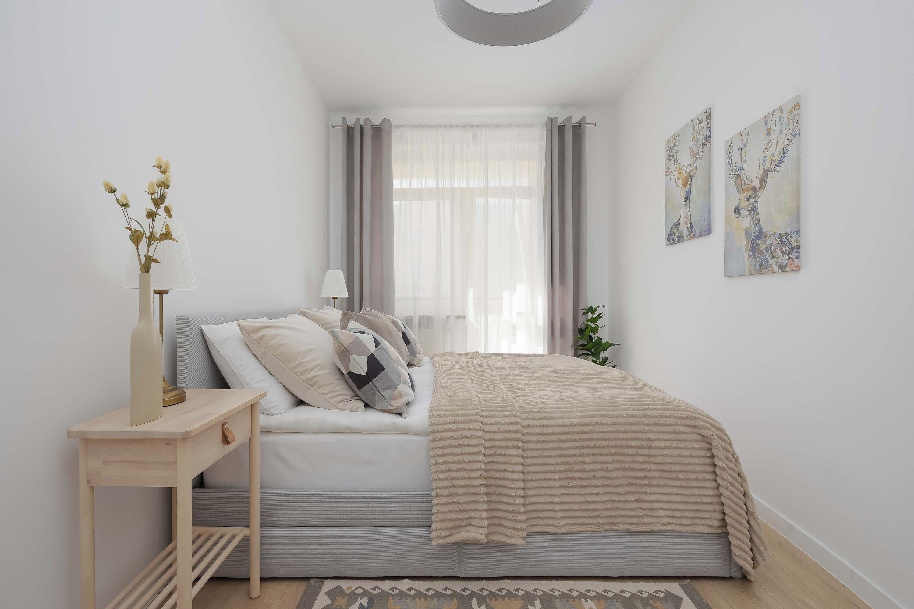Una camera da letto con un letto, un comodino, una lampada e un'opera d'arte.