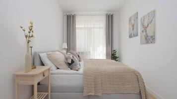 Una camera da letto con un letto, un comodino, una lampada e un'opera d'arte.