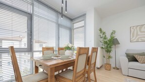Ein Essbereich mit Holztisch, Stühlen und einer Blumenvase.