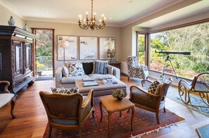 A spacious living room with a sofa, chairs, a chandelier, and a telescope. - Boyanda (Ferny Creek)