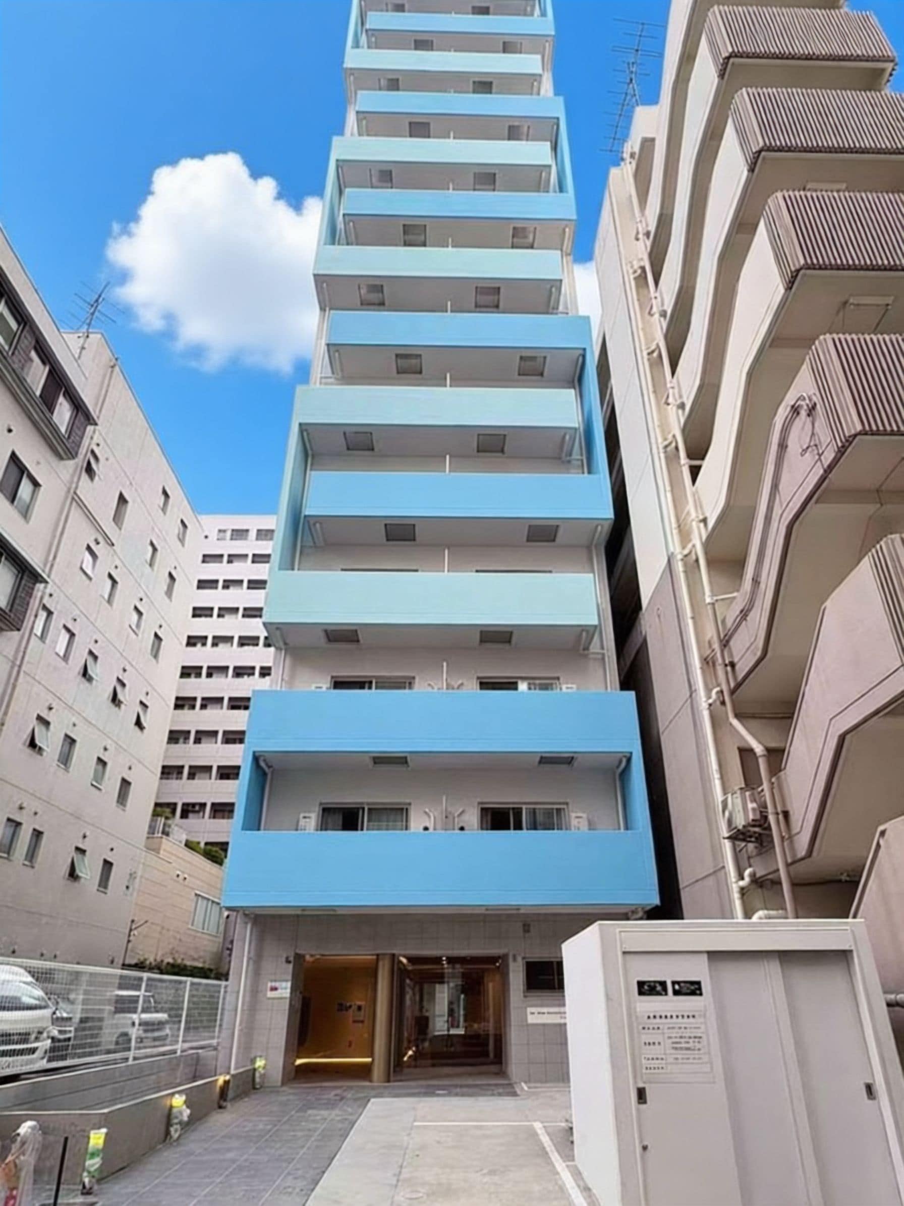 A multi-story building with a blue facade and a ground-level entrance.