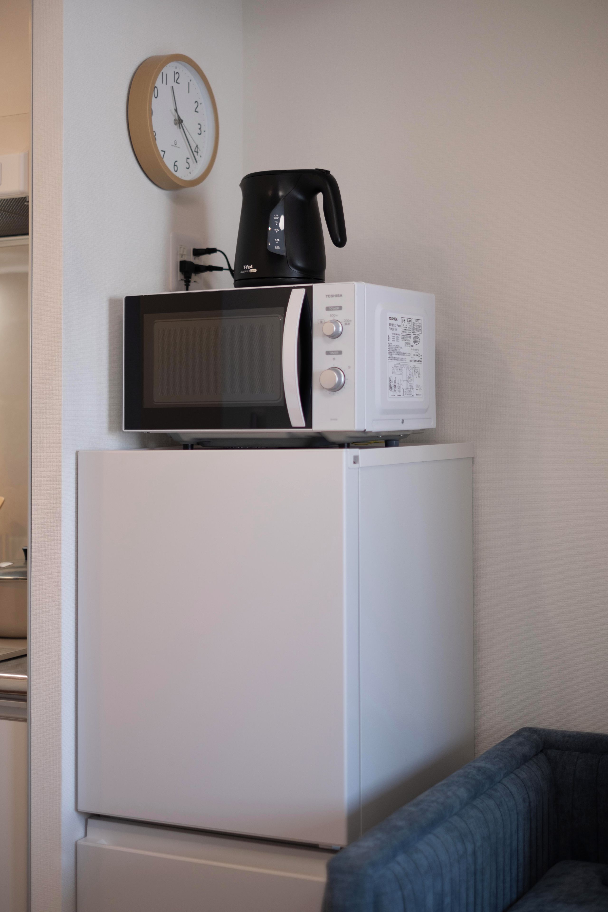 A white refrigerator with a microwave and a coffee maker on top.