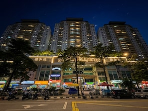A multi-story building with illuminated signage, a prominent entrance, and surrounding commercial establishments. - Putra Majestik Manage By PP (Cheras)