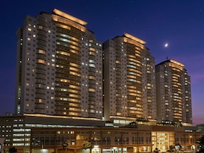 A high-rise hotel with multiple floors, illuminated windows, and a visible crescent moon in the sky. - Putra Majestik Manage By PP (Cheras)