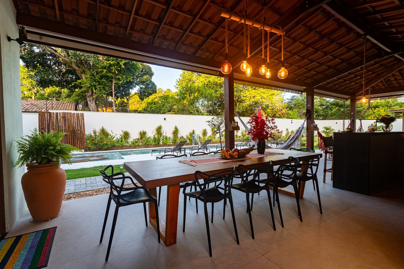 Un espace extérieur aménagé pour les repas, avec une piscine, des chaises et une table.