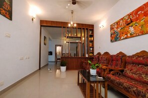 A living room with a sofa, a coffee table, and a decorative mirror. - Namasthe Wellness Hotel (Aluva)