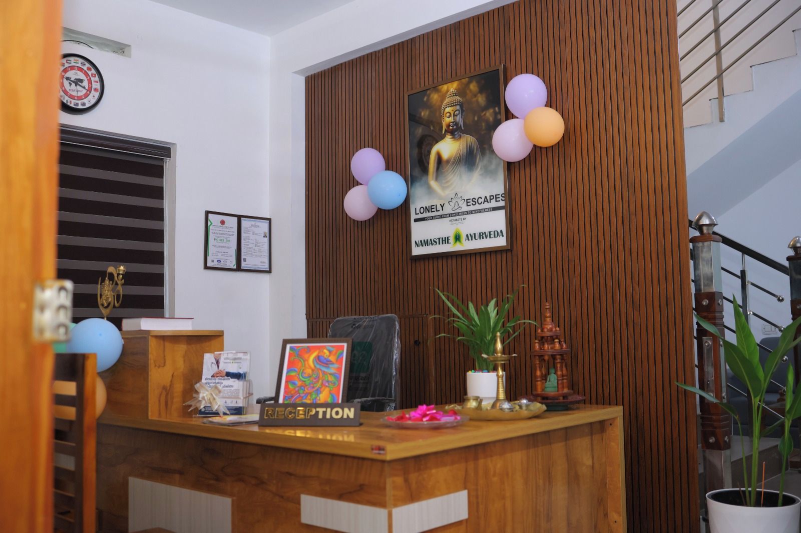 A reception desk with a wooden finish, a framed poster, a clock, and certificates on the wall.