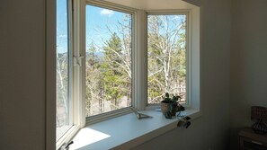 A room with a large window overlooking a forested area. - Hilltop Haus: Sweeping Mountain Views Above Denver (Morrison)