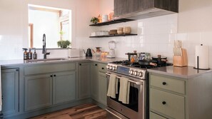 A kitchen with a stove, oven, and various appliances. - Hilltop Haus: Sweeping Mountain Views Above Denver (Morrison)