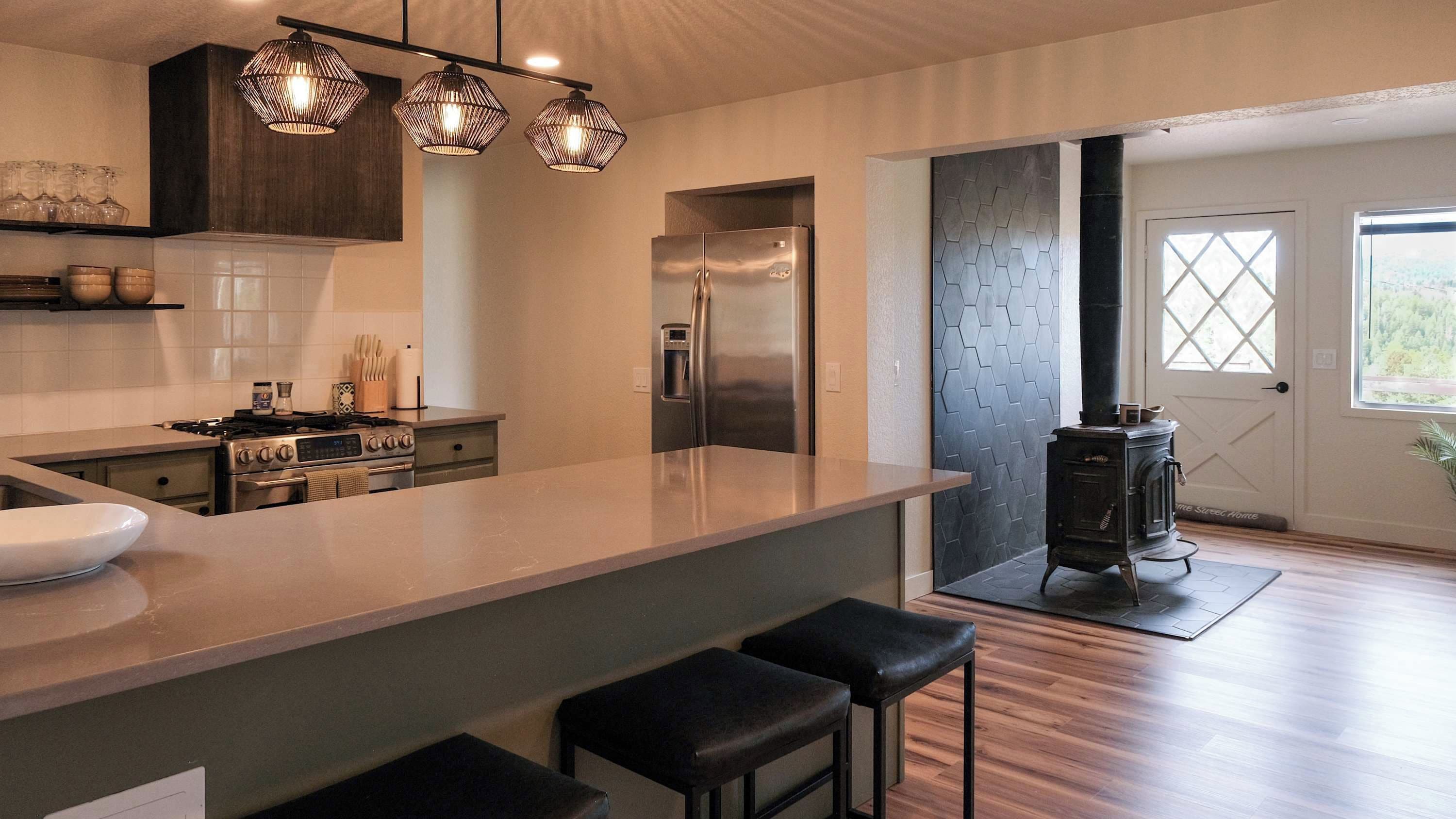Una cocina moderna con una isla central, electrodomésticos de acero inoxidable y una estufa a leña.