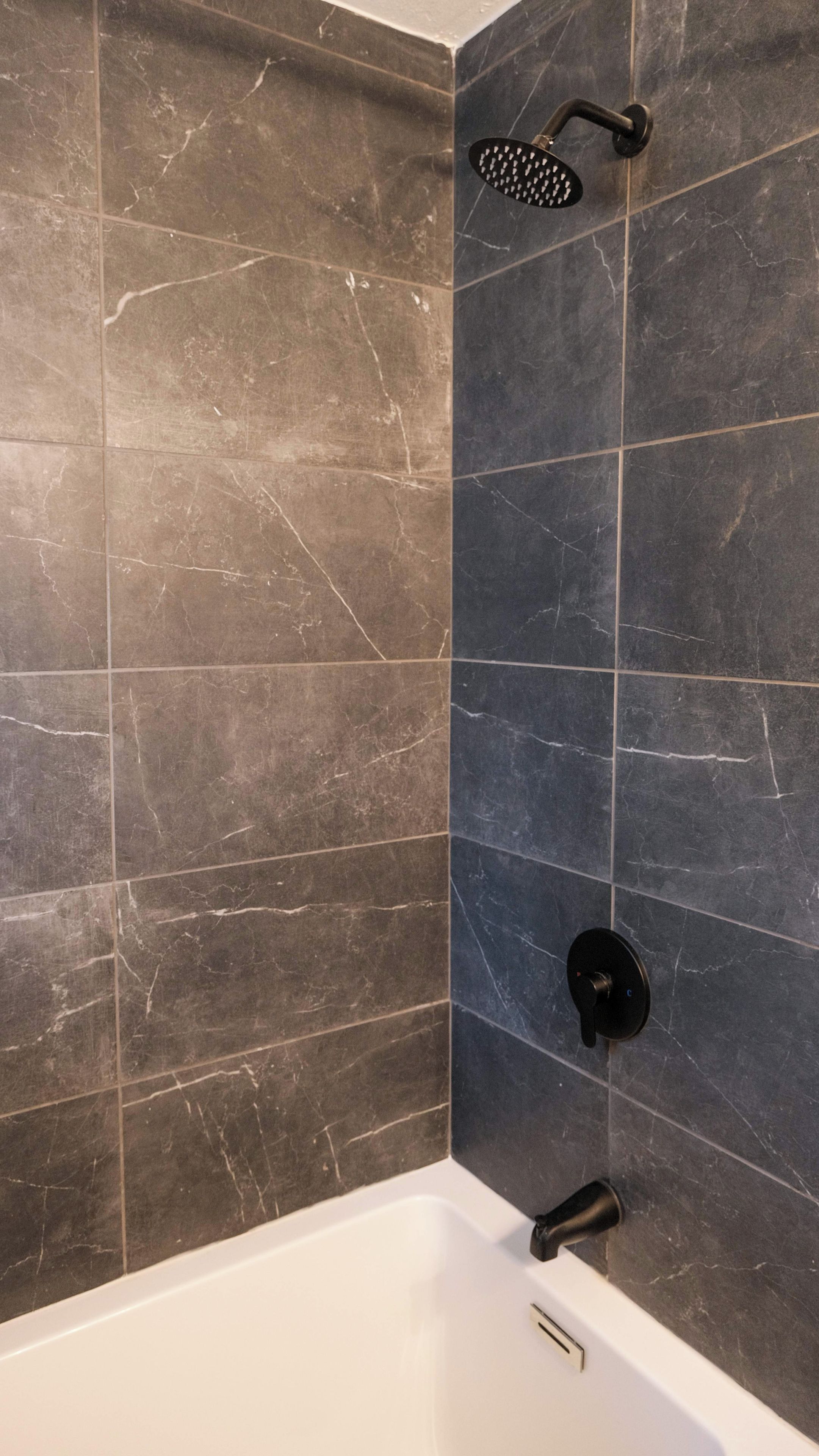 Une salle de bain avec une baignoire, une pomme de douche et un robinet.
