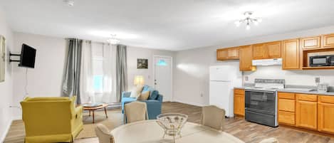 Een knus woongedeelte met een eethoek, een bank, een televisie en een kitchenette.