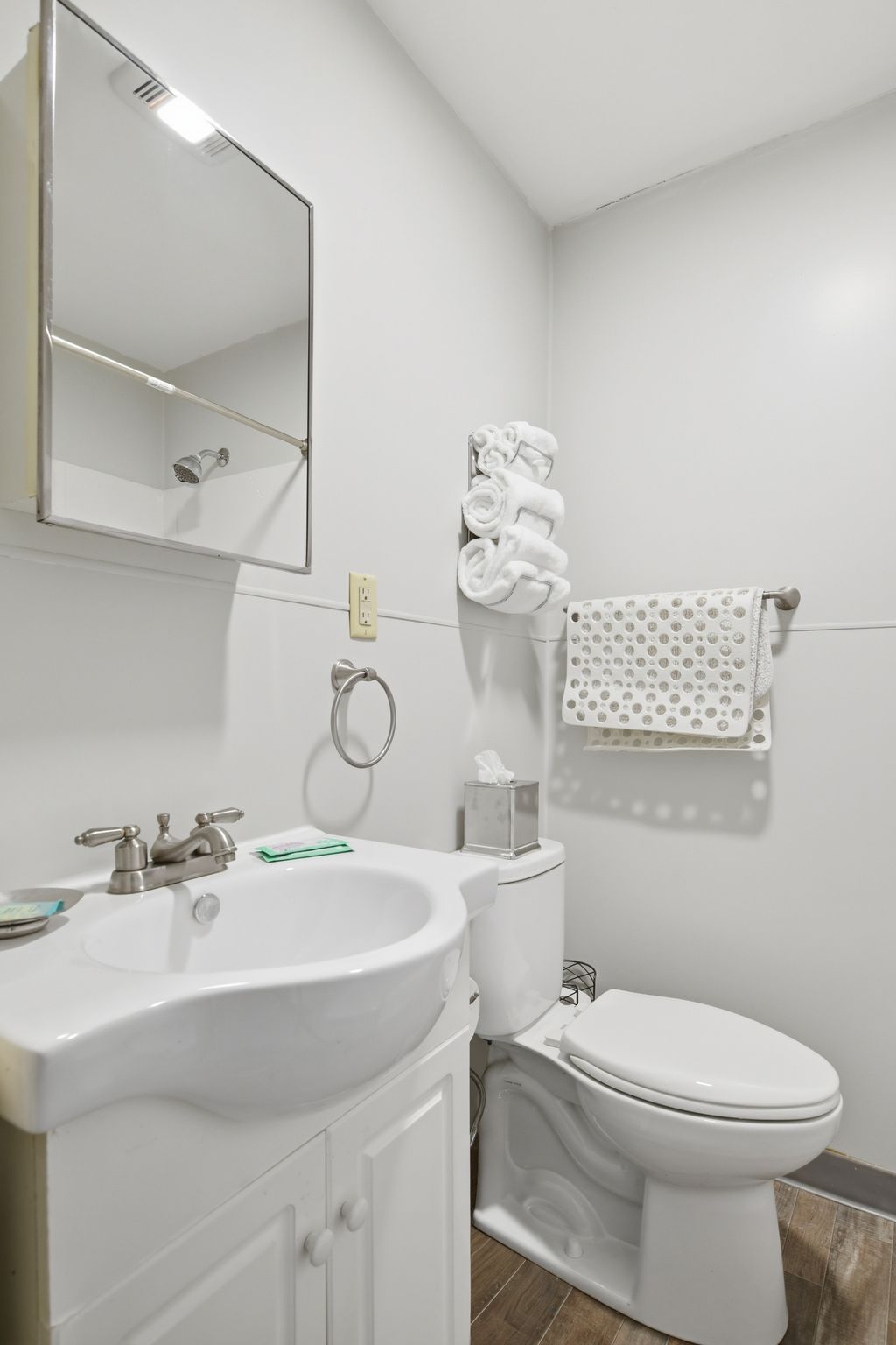 Un baño con lavabo, inodoro y toallero.