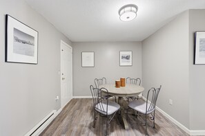 A dining area with a round table, four chairs, and two framed pictures on the walls. - Trainmaster's Inn - 1294 South Main, Apt 2 (Palmer)