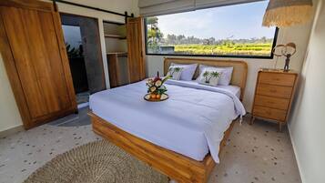 Quarto com cama, cômoda de madeira, janela com vista para um campo e porta deslizante.