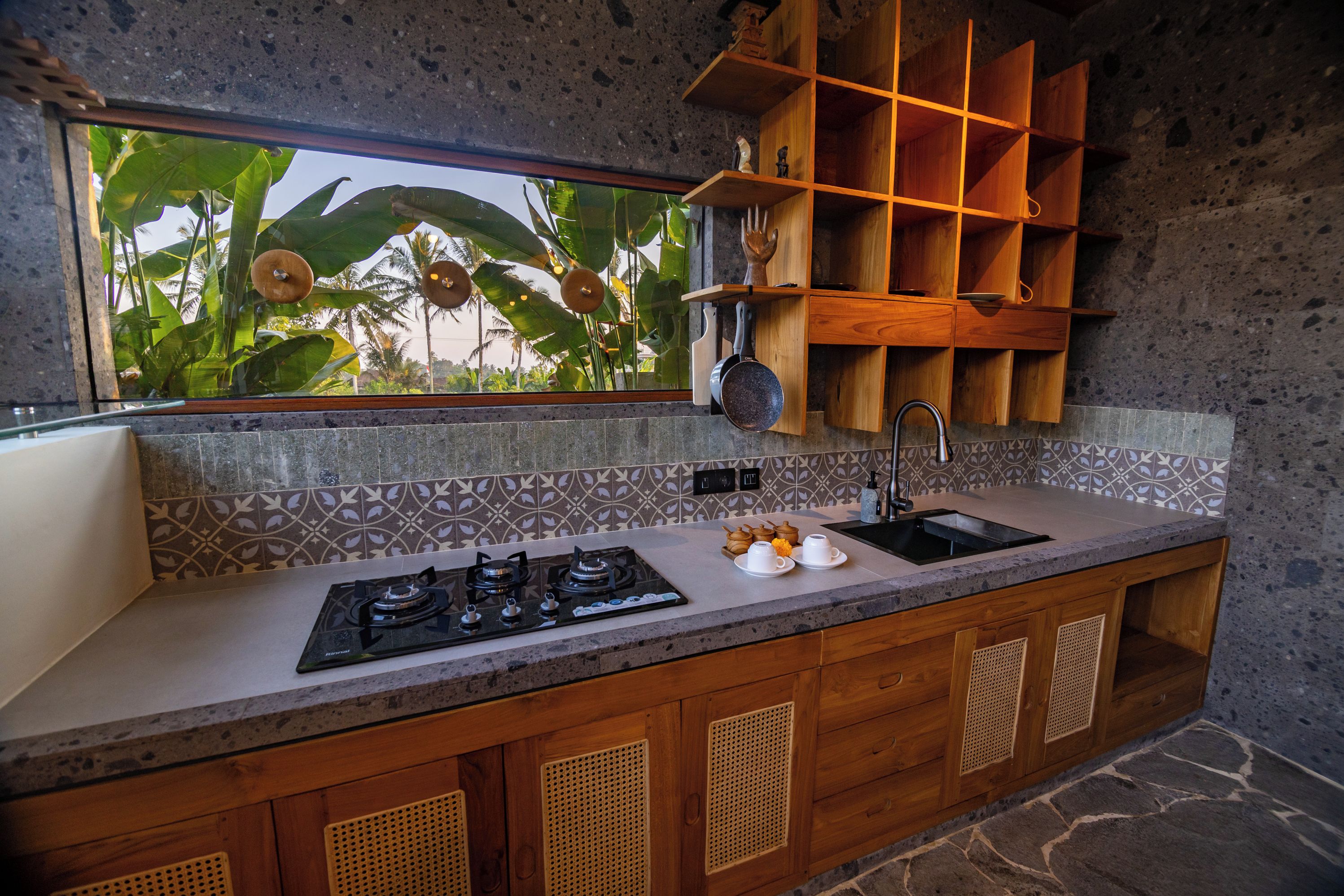 Cocina con estufa a gas, pileta y muebles de madera.