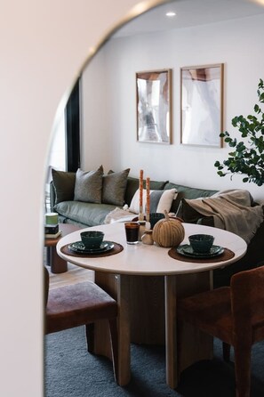 Un comedor acogedor con una mesa redonda, sillas y un sofá al fondo.