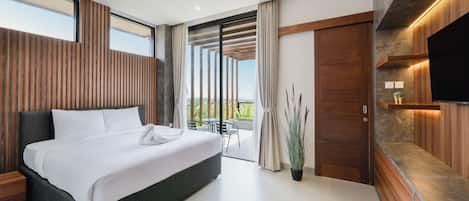A modern hotel room with a large bed, a balcony with a view, and a flat-screen TV mounted on the wall.