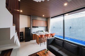 A modern kitchen with a marble countertop, wooden cabinets, and a built-in stove.