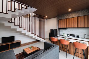 A modern interior with a staircase, living area, and kitchen.