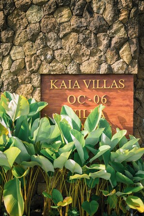 A wooden sign with the text 'KAIA VILLAS OC-06' against a stone wall background. - Cozy 2 BR Nusa Dua Villa with Private Pool (Badung)