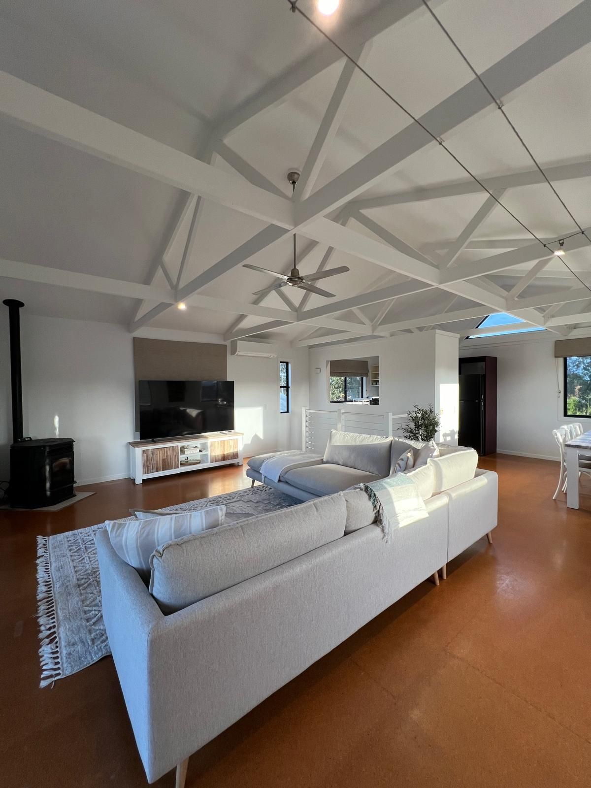 A spacious living room with a large sofa, a flat-screen TV, and a fireplace.