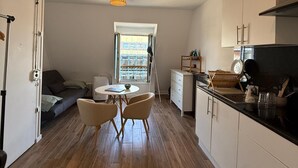 Uma cozinha compacta com área de refeições, uma janela com vista e um lustre.