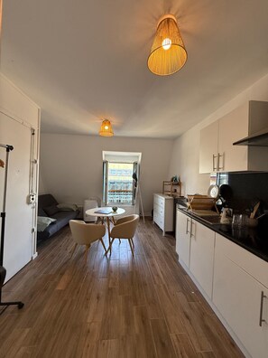 Et lille køkken med spiseplads, et vindue med udsigt og en loftlampe.