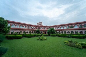 A large building with a central courtyard, multiple arches, and a symmetrical design. - Omji Ashram - Udasin Sangat Rishi (Ayodhya)