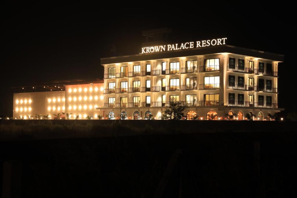A multi-story hotel named 'Krown Palace Resort' with illuminated windows and balconies.