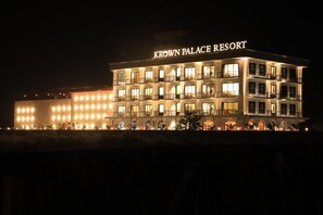 A multi-story hotel named 'Krown Palace Resort' with illuminated windows and balconies.