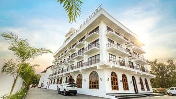 A multi-story hotel with balconies, arched windows, and a clear sky.
