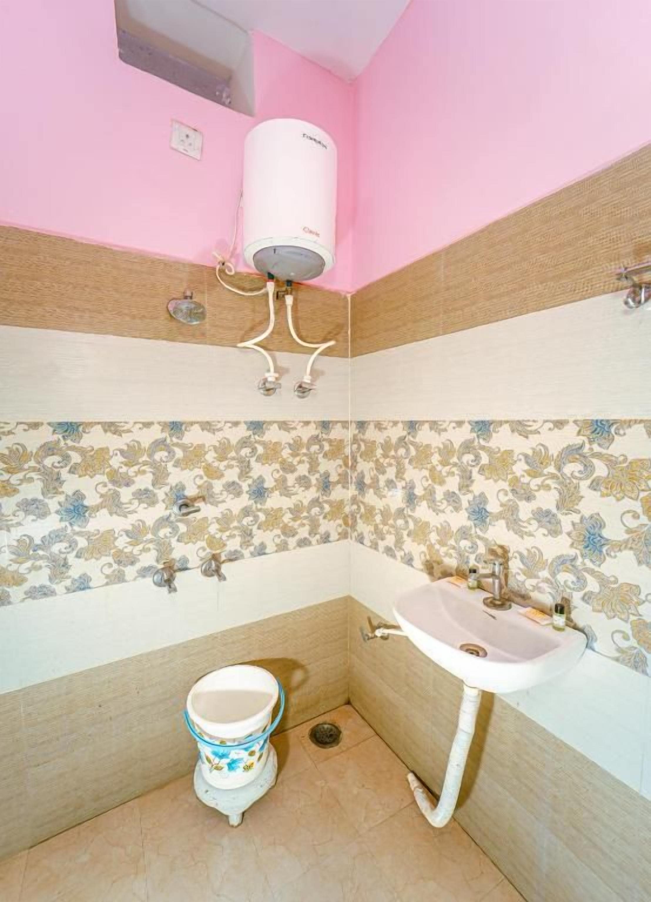 A bathroom with a toilet, sink, and a water heater mounted on the wall.