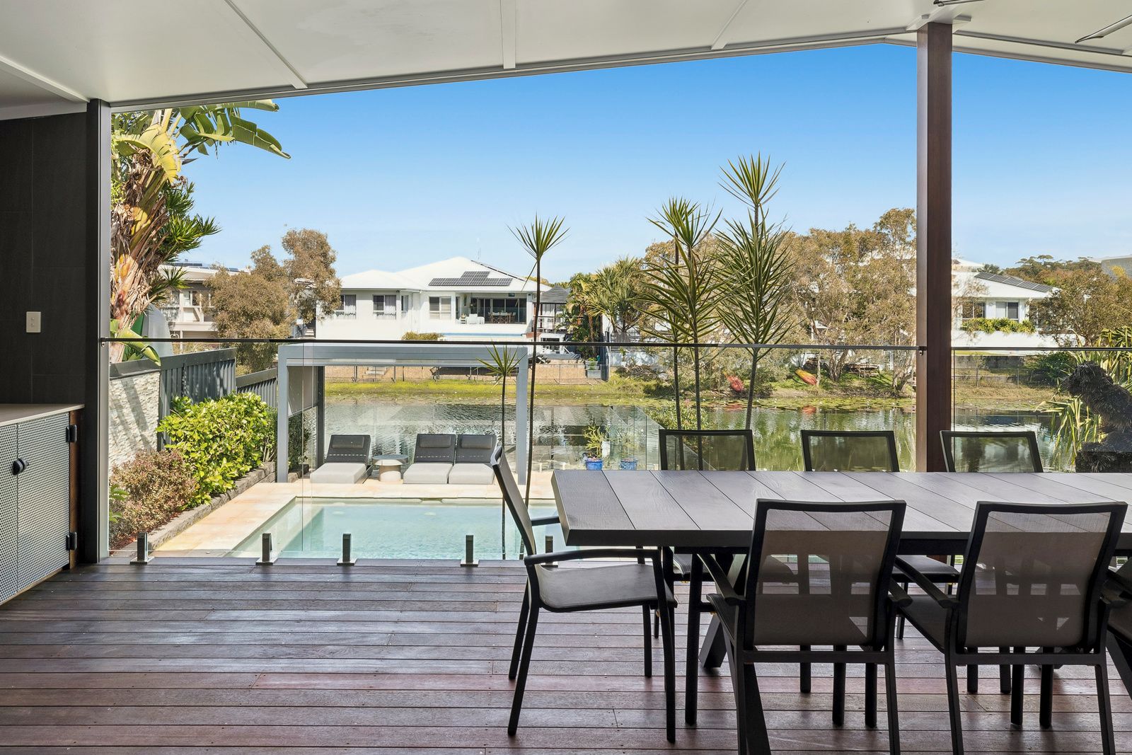 An outdoor patio with a pool, seating area, and a view of the surrounding landscape.