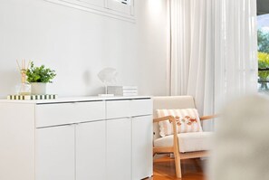 A white cabinet with a plant and a decorative item on top. - Paradise Palms | Walk to Beach | Boat Parking (Agnes Water)